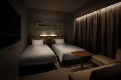 a small room with two beds and a couch at Bespoke Hotel Shinjuku in Tokyo