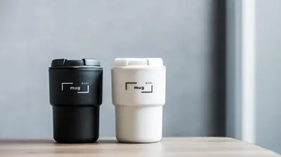 two coffee cups sitting next to each other on a table at Bespoke Hotel Shinjuku in Tokyo