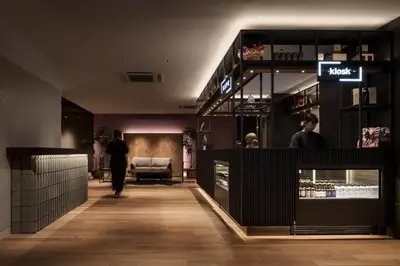 a woman walking down a hallway in a store at Bespoke Hotel Shinjuku in Tokyo