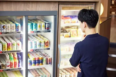 a man looking inside of an open refrigerator at ANA Holiday Inn Tokyo Bay by IHG in Tokyo