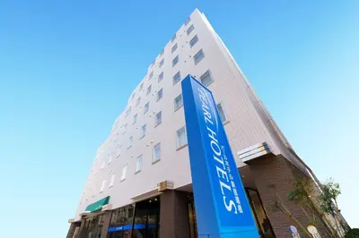 a building with a blue sign in front of it at Pearl Hotel Shinjuku Akebonobashi in Tokyo