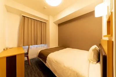 a hotel room with a bed and a desk at Pearl Hotel Shinjuku Akebonobashi in Tokyo