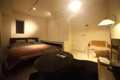 a bedroom with a bed and a table and a lamp at Sorapia Tokyo in Tokyo