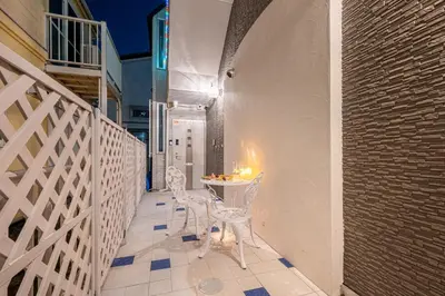 a balcony with a table and chairs and a wall at Papillon Paradis Nishi-Shinjuku in Tokyo