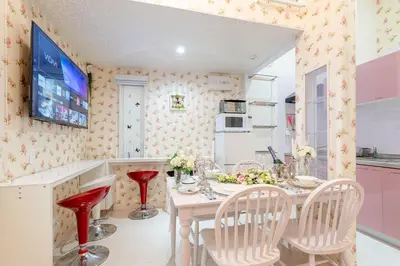 a kitchen with a table with chairs and a tv at Papillon Paradis Nishi-Shinjuku in Tokyo