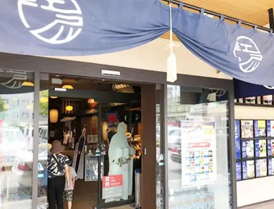 a person standing in front of a store with a blue canopy at Tokyo inn Sakura An in Tokyo