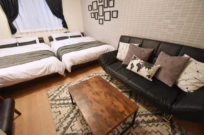 a living room with a couch and a bed and a table at Origami Residential Suite - Tokyo Asakusa Skytree in Tokyo