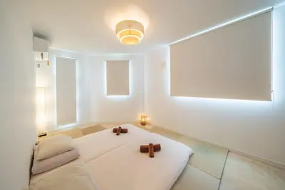 a white room with a white couch with two crosses on it at QiQi House Tokyo まるごと新築一軒家宿 Spacious New Home, 8 Guests, Easy Airport & Disney Access in Tokyo