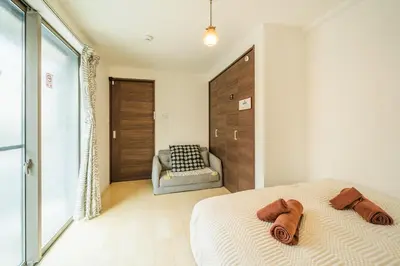 a bedroom with a bed and a chair in it at QiQi House Tokyo まるごと新築一軒家宿 Spacious New Home, 8 Guests, Easy Airport & Disney Access in Tokyo