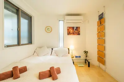 a bedroom with two beds and a window at QiQi House Tokyo まるごと新築一軒家宿 Spacious New Home, 8 Guests, Easy Airport & Disney Access in Tokyo