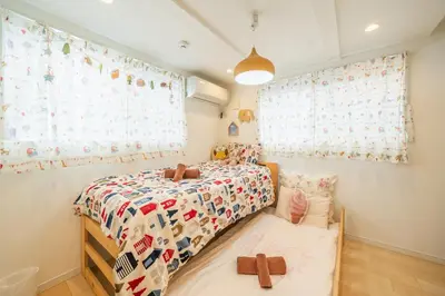 a childs bedroom with a bed and two chairs at QiQi House Tokyo まるごと新築一軒家宿 Spacious New Home, 8 Guests, Easy Airport & Disney Access in Tokyo