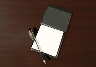 a black wallet with a pen on a wooden table at Hotel Trend Asakusa Tawaramachi in Tokyo