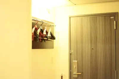 a hallway with a door and a bunch of shoes at Hotel New Takada in Tokyo