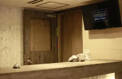 a bathroom with a sink with a mirror and a door at Hotel New Takada in Tokyo
