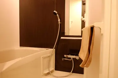 a bathroom with a bath tub with a shower at Universal Haneda in Tokyo