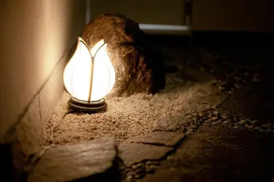 a lamp sitting on the floor next to a rock at Shin Okubo Sekitei in Tokyo