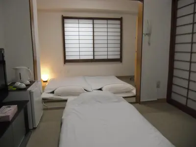 two beds in a room with a window at Shin Okubo Sekitei in Tokyo