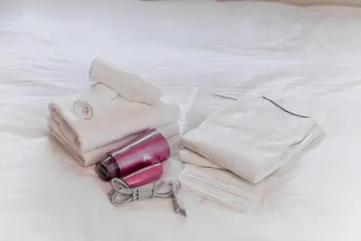 a group of towels and a bottle on a bed at GLOU Higashi Shinjuku in Tokyo