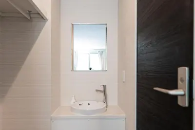 a bathroom with a sink and a mirror at GLOU Higashi Shinjuku in Tokyo