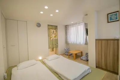 a bedroom with two beds and a table in it at Takadanobaba 3-1F in Tokyo