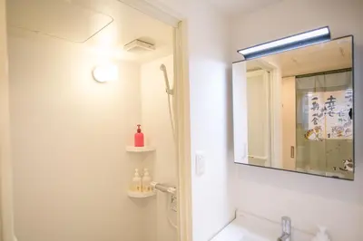 a bathroom with a mirror and a sink at Takadanobaba 3-1F in Tokyo
