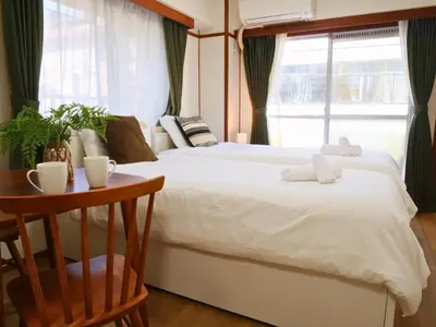 a bedroom with a bed and a table and a window at Amber Iidabashi in Tokyo