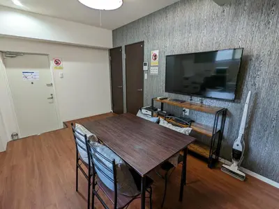 a dining room with a table and a tv at Amber Iidabashi in Tokyo