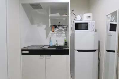 a small white kitchen with a sink and a microwave at Shibuya Stay Tokyo A202 in Tokyo