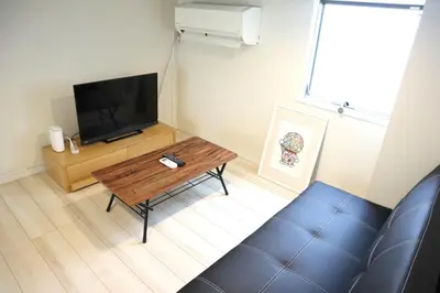 a living room with a wooden coffee table and a flat screen tv at Shibuya Stay Tokyo B102 in Tokyo