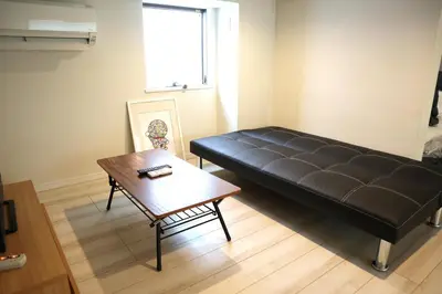 a black couch in a room with a table at Shibuya Stay Tokyo B102 in Tokyo
