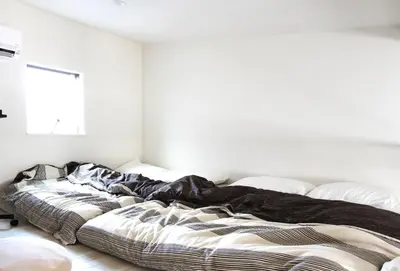 an unmade bed in a room with white walls at Shibuya Stay Tokyo B204 in Tokyo