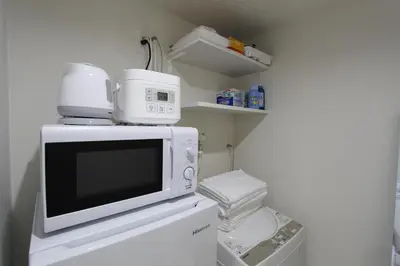 a microwave oven sitting on top of a refrigerator at Shibuya Stay Tokyo B204 in Tokyo