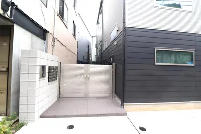 a white door on a building next to a sidewalk at Shibuya Stay Tokyo B204 in Tokyo