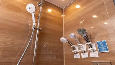 a shower with two shower heads on a wall at Tokyu Stay Shibuya in Tokyo