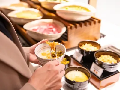 a person is eating food in bowls on a buffet at Asakusa View Hotel in Tokyo