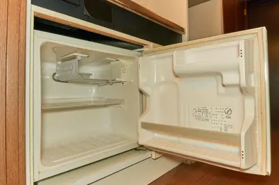 an empty refrigerator with its door open in a kitchen at Garden Otsuka in Tokyo