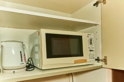 a microwave oven sitting on a shelf in a kitchen at Garden Otsuka in Tokyo