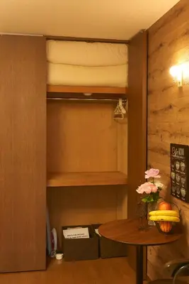 a room with a table and a cupboard with a bed at Garden Otsuka in Tokyo