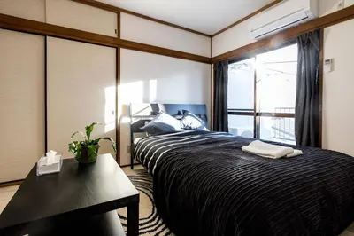 a bedroom with a bed with a desk and a window at Ikebukuro Yamase Building #GR1 in Tokyo