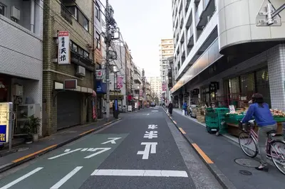 a person riding a bike down a city street at Ikebukuro Yamase Building #GR1 in Tokyo