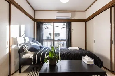 a bedroom with a bed and a table and a window at Ikebukuro Yamase Building #GR1 in Tokyo