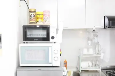 a microwave oven sitting on top of a refrigerator at Shinjuku Sunrise Apartment in Tokyo