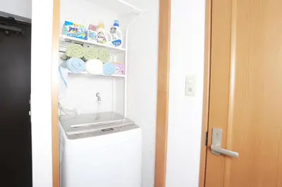 a washer and dryer in a small room at Shinjuku Sunrise Apartment in Tokyo