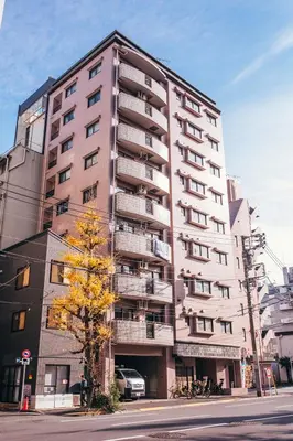 a tall building with a tree in front of it at nestay apartment tokyo akihabara in Tokyo