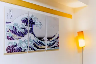 a painting hanging on a wall in a room at nestay apartment tokyo akihabara in Tokyo