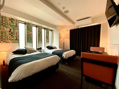 two beds in a hotel room with windows at Residence Condominium KALAHAAI in Tokyo