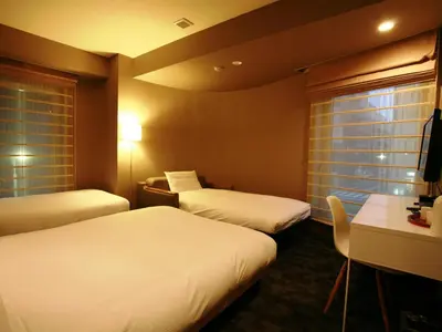 a hotel room with two beds and a desk at Agora Place Tokyo Asakusa in Tokyo