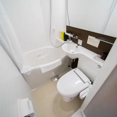 a small bathroom with a toilet and a sink at Super Hotel Tokyo Hamamatsucho in Tokyo