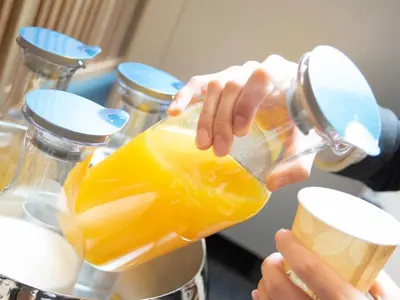 a person drinking a glass of orange juice at Super Hotel Tokyo Hamamatsucho in Tokyo