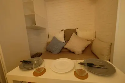 a table with plates and glasses and a couch at COCO Nakameguro 201 in Tokyo
